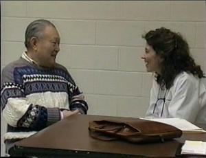 Man in sweater talking to female doctor