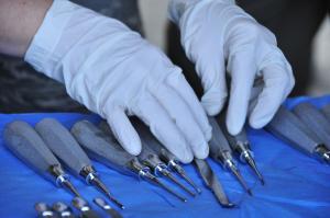 Hands with white gloves arranging dental tools