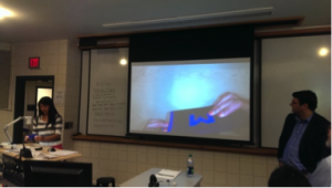 Female student giving lecture with overhead screen