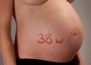 Exposed pregnant stomach with the text 38 w written on the stomach