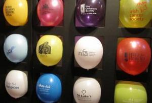 Multi-colored balloons with different hospital logos arranged in grid