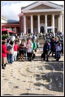 Students outside university building next to a circle of candles