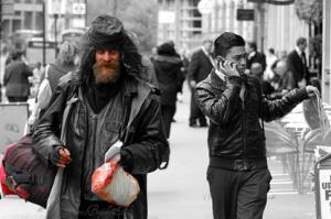disheveled man with unkempt beard walks down the street carrying his belongings
