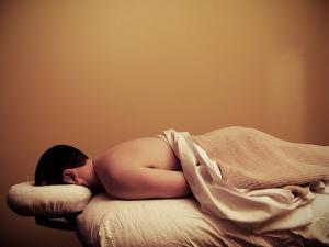 Photo of man laying face-down on massge table